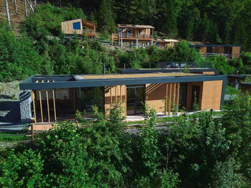 a house on the side of a hill with trees at UplandParcs Sauerland in Winterberg