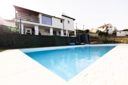 a swimming pool in front of a house at Casa no cimo do Douro in Loureiro