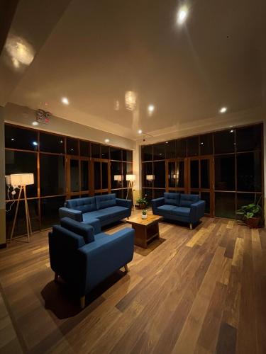 a large room with blue couches in a building at Terrazas 3400 Lodge in Oxapampa