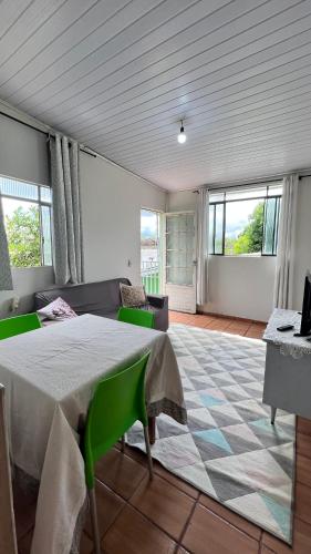 a room with a table and a couch and windows at Casa próxima ao Centro de Foz in Foz do Iguaçu