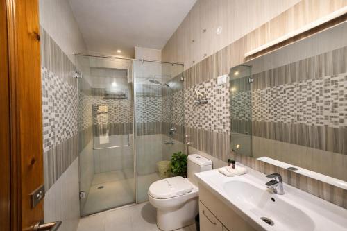a bathroom with a toilet and a sink and a shower at Manali Valley Resort in Manāli