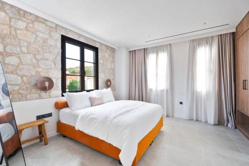 a bedroom with a large bed and a stone wall at Képos Villas Sivota in Syvota