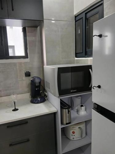 a small kitchen with a microwave and a refrigerator at le laurier 9 in Abidjan