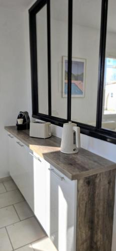 a kitchen with white cabinets and a counter with windows at Villa Elara provençale avec piscine 4 étoiles in Sarrians