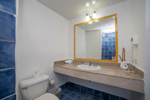 a bathroom with a toilet and a sink and a mirror at Hotel Croma Sosua Beach in Sosúa