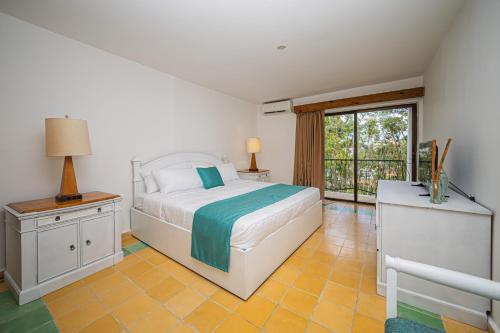 a bedroom with a bed and a large window at Hotel Croma Sosua Beach in Sosúa