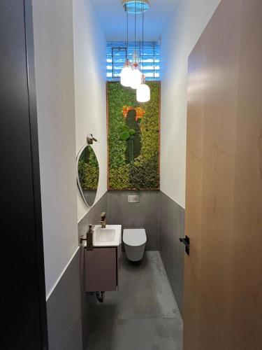 a bathroom with a sink and a painting on the wall at Forest Haus in Schlangenbad