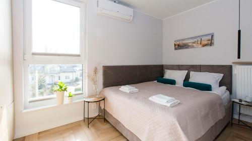 a bedroom with a large bed with a window at Apartament 19A - Villa Neptun in Gdańsk