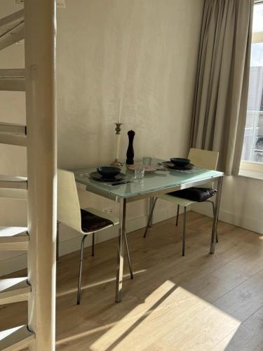 a dining room table with two chairs and a vase on it at Studio Jordaan Amsterdam City Centre in Amsterdam