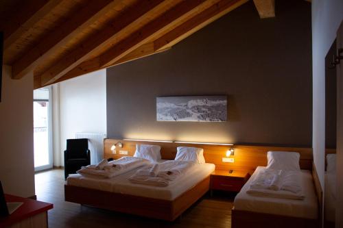 a bedroom with two beds with lights on the wall at Hotel Auwirt Zentrum in Saalbach-Hinterglemm