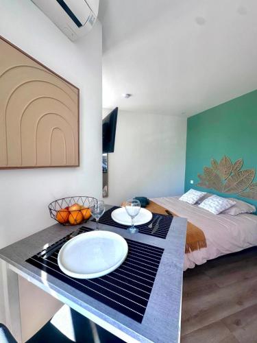 a room with a bed and a table with plates on it at Les suites du pont Joffre in Perpignan