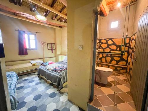 a bedroom with a bed and a toilet in a room at Riad Bouchra in Tinerhir