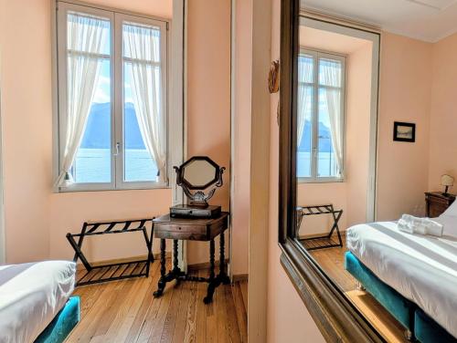 a bedroom with two beds and a mirror at Appartamento Principe in Menaggio