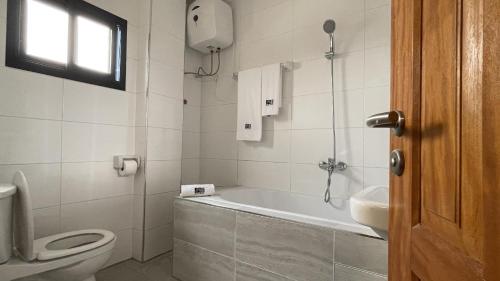 a bathroom with a tub and a toilet and a sink at JPN SQUARE Douala in Douala