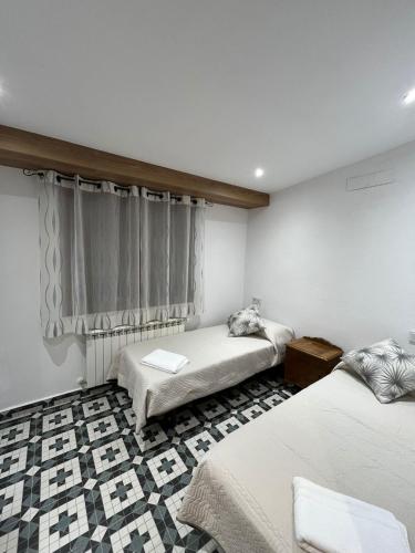 a bedroom with two twin beds and a window at La casa de Inocen in Cilleruelo