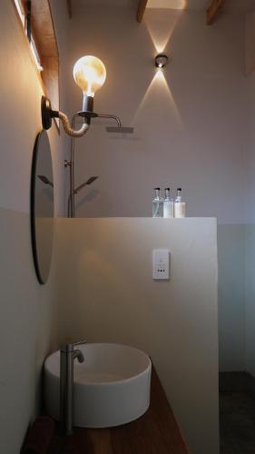 a bathroom with a sink and a light and a mirror at Our Stay Mlima in Arusha