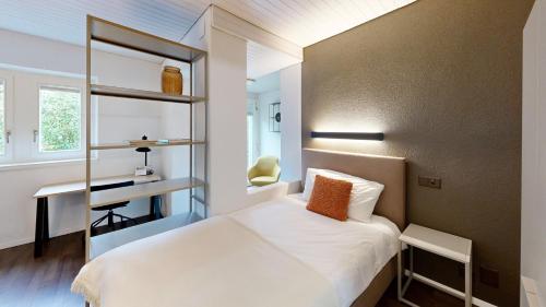 a small bedroom with a bed and a desk at Apartmenthouse Viktoria in Bern in Bern