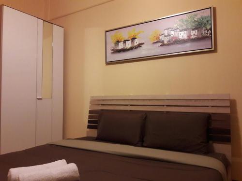 a bedroom with a bench and a painting on the wall at Navavilla Serviced Apartment in Ban Lam Rua Taek
