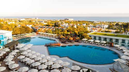 an aerial view of a resort with a pool and umbrellas at Chamada Prestige Hotel and Casino in Kyrenia