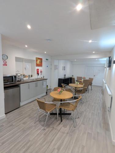 a room with tables and chairs and a kitchen at The Hive Great Yarmouth in Great Yarmouth
