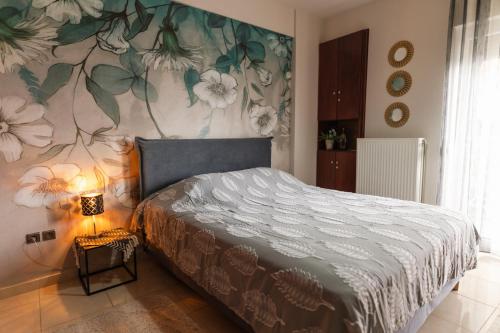 a bedroom with a bed with a floral wall at MariZot Apartment in Alexandroupoli