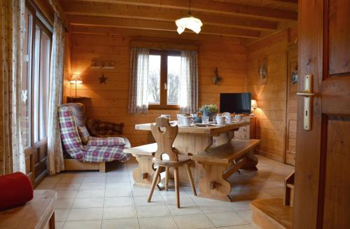 Saint-EustacheにあるGîtes Les Praletsのテーブルと椅子のある木造の部屋