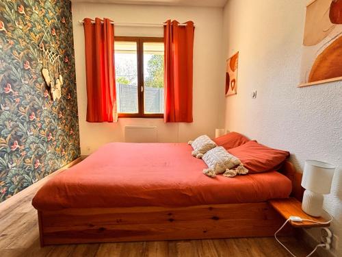 a bedroom with a bed with a stuffed animal on it at Gîte Le Sallèles in Sallèles-dʼAude