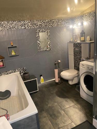a bathroom with a toilet and a sink and a tub at Pavillon Val in Romainville