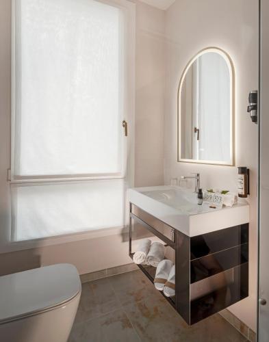 a white bathroom with a sink and a mirror at Ai Due Fanali in Venice