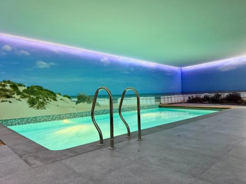 a swimming pool with two metal hand rails next to it at Camelia 0202 - With Swimming Pool in Koksijde