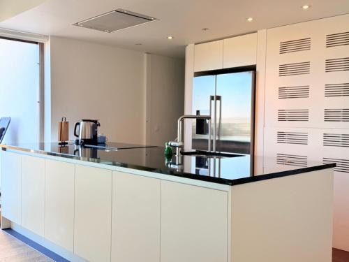 a kitchen with white cabinets and a black counter top at Camelia 0202 - With Swimming Pool in Koksijde