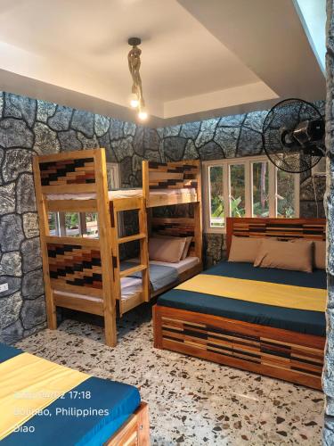 a bedroom with two bunk beds and a stone wall at Farmhouse With Ocean View in Bolinao