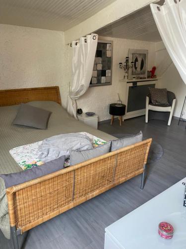 una camera da letto con un grande letto con struttura in vimini di Pavillon Val a Romainville