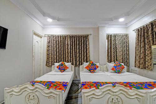 a bedroom with two beds with colorful pillows at FabHotel Wellesley in Kolkata