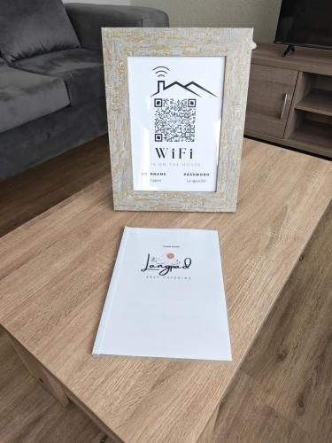 a white sign on a coffee table in a living room at Langpad Self Catering in Frankfort