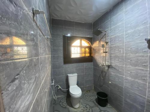 a bathroom with a toilet and a window at KFP Serene and Modern 2BR Flat , IBD in Ibadan