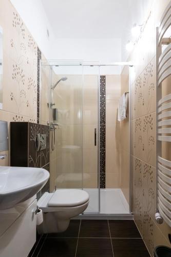 a bathroom with a shower and a toilet and a sink at Leszczynowy Dworek in Gdańsk