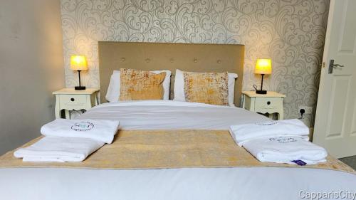 a bedroom with a large bed with towels on it at 12A-2 Stobhill Road in Arniston