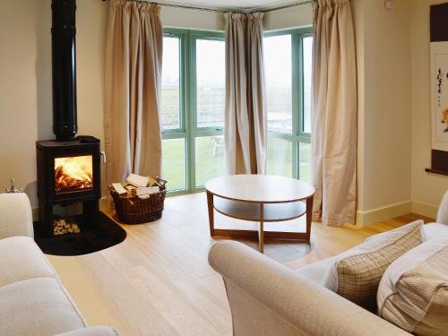 a living room with a fireplace and a couch and a table at Petronella in Grange