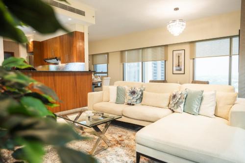 a living room with a couch and a table at Nasma Luxury Stays - Central Park Tower in Dubai