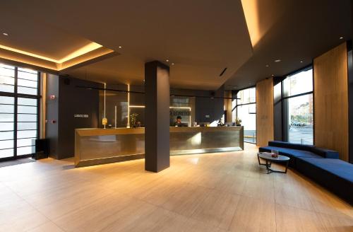 a lobby with a couch and a bar in a building at Palazzo Loreto Hotel Milano in Milan