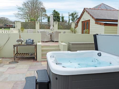 a hot tub on the patio of a house at Cefn Y Gwynt in Llangranog