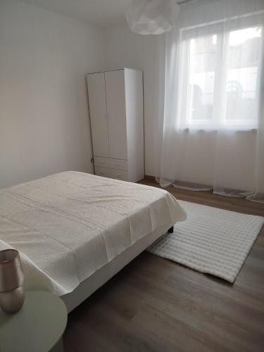 a white bedroom with a bed and a window at Light Loft Marsciano in Marsciano