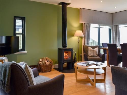 a living room with a wood stove in a room at Strathspey in Grange