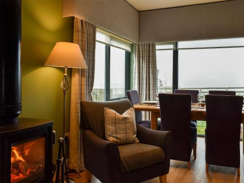 a dining room with a fireplace and a table with chairs at Strathspey in Grange