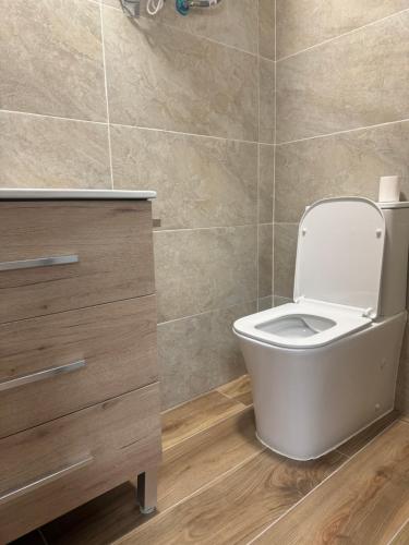 a bathroom with a white toilet in a room at Casa Pepe in Ourense