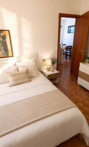a bedroom with a large white bed and a dining room at Capo d'Arco Residence Bilocale tra Mare e Natura in Capo D'Arco