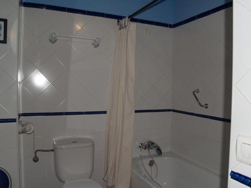 a bathroom with a toilet and a tub and a shower at La casa del Vado in Hervás
