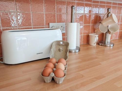 a bunch of eggs in a basket on a kitchen counter at Lephin Cottage in Glendale