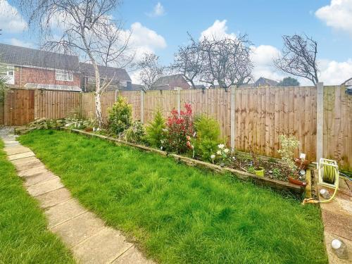 a backyard with a wooden fence and green grass at Sunrise Villa in Clacton-on-Sea